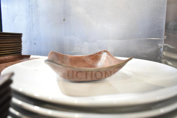 A mixed lot featuring a rectangular wooden plate on stacked white ceramic plates, alongside textured baskets.
