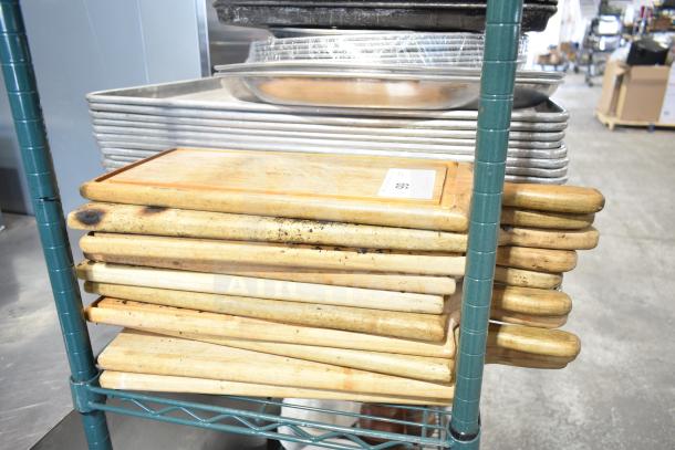 A collection of assorted kitchen items, including baking pans, wooden cutting boards, and other cookware stacked on a metal shelf.