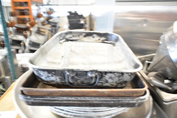 Tier lot including baking pans, stainless steel bins, china cap strainer, stock pot, cutting boards, and knives, used condition.