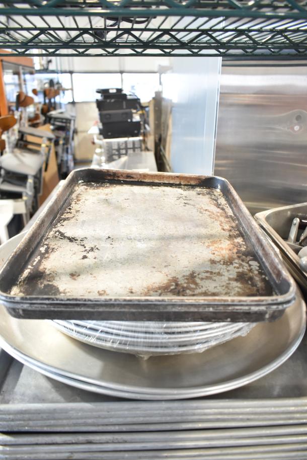 Alt text: Assorted kitchen items including baking pans, stainless steel bins, and more on metal shelves. Items show heavy use.