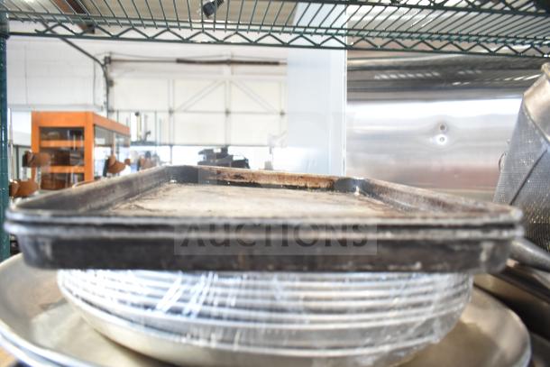 Various kitchen items including baking pans, cutting boards, knives, china cap strainer, and stock pot stacked on shelving.