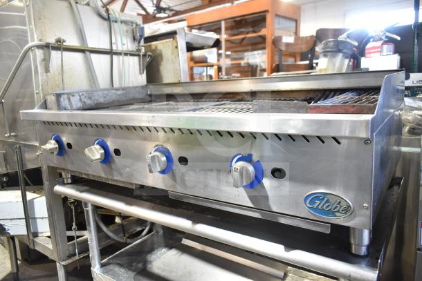 Globe commercial countertop gas charbroiler grill with blue control knobs on equipment stand with commercial casters.