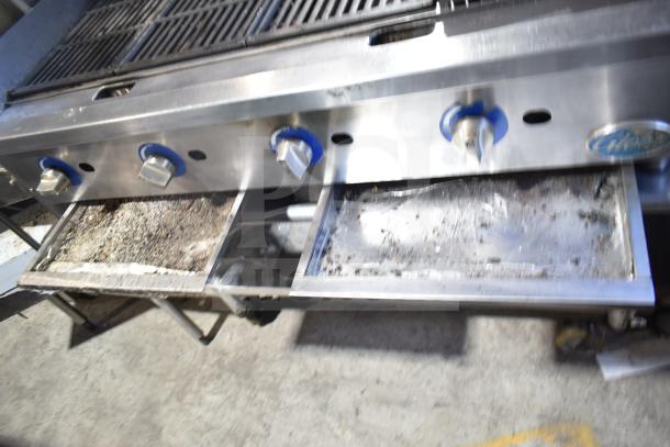 Globe countertop gas charbroiler grill on stand with commercial casters, stainless steel, visible soiling on drip trays.