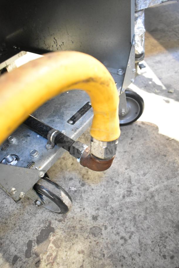 2024 Qualite QL-9/NG commercial gas fryer bottom view; visible gas connector and wheels. Model and label parts shown.