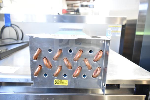 Brand new evaporator coil with visible copper tubing. Minor scratches, factory label with QR code on metal casing.
