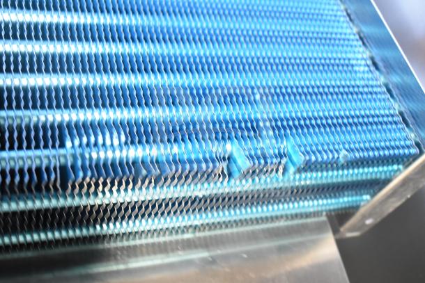 Brand new evaporator coil with visible scratches and dents, blue metallic finish, ideal for HVAC systems.