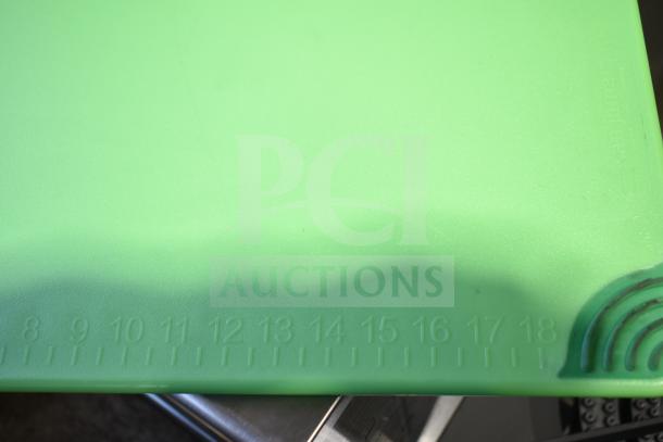 Brand new green cutting board with minor scratches. Features inch markings along edge for precise measurements.