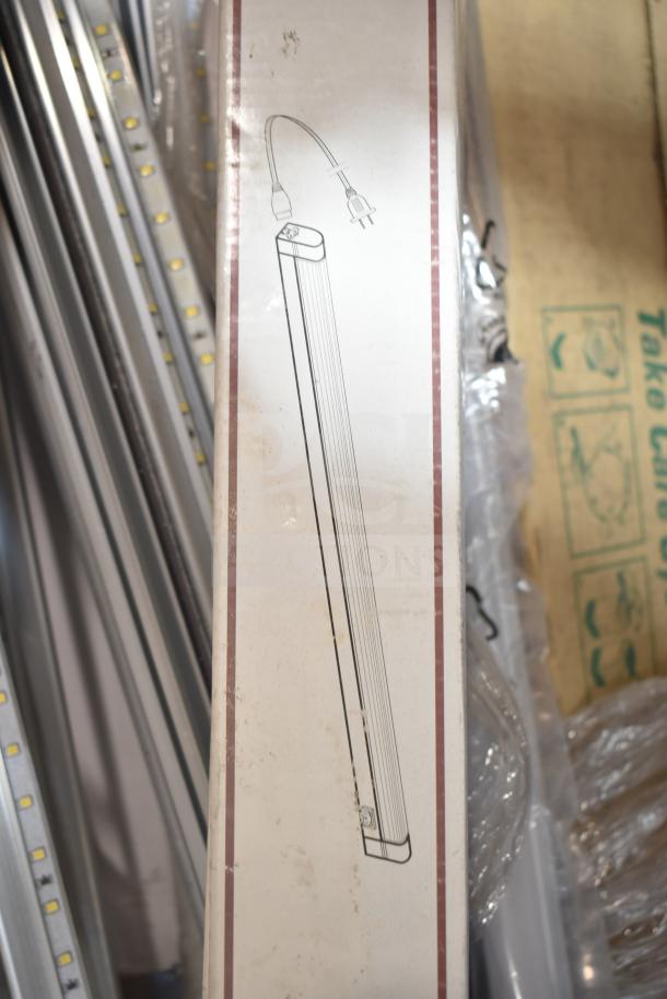 Boxed fluorescent tube light, brand new with minor scratches, electrical cord illustrated on packaging, part of auction lot of 12.