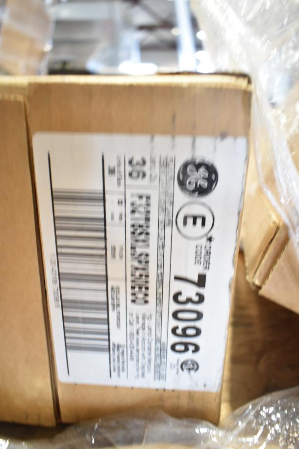 Box of 12 brand new scratch and dent items. GE label visible with code 73096, includes fluorescent tube lights.