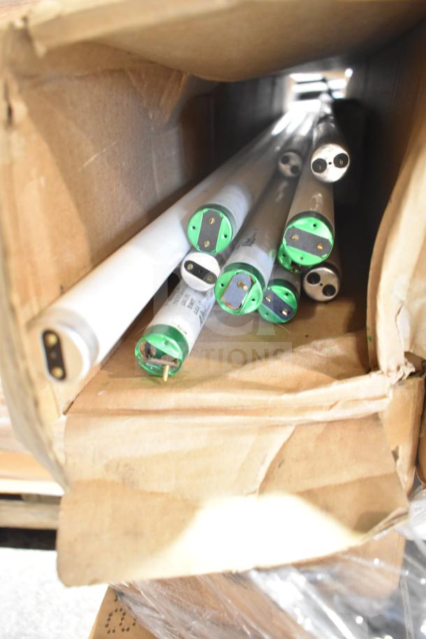 Box with 12 new fluorescent tube lights, scratch and dent condition, showing green end caps and prongs for connectivity.