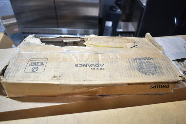 Cardboard box marked "Philips Advance" containing 20 new fluorescent tube lights, some with minor scratches and dents.