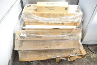 Boxes of GE fluorescent tube lights, labeled as scratch and dent, wrapped in plastic. New condition, visible part ID.