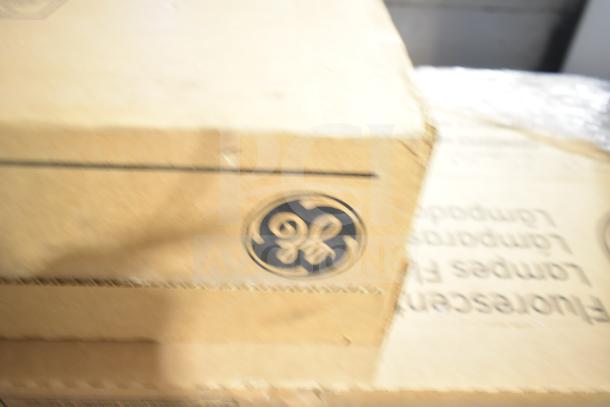 Brown cardboard boxes labeled with GE logo containing fluorescent tube lights, brand new with scratch and dent condition.