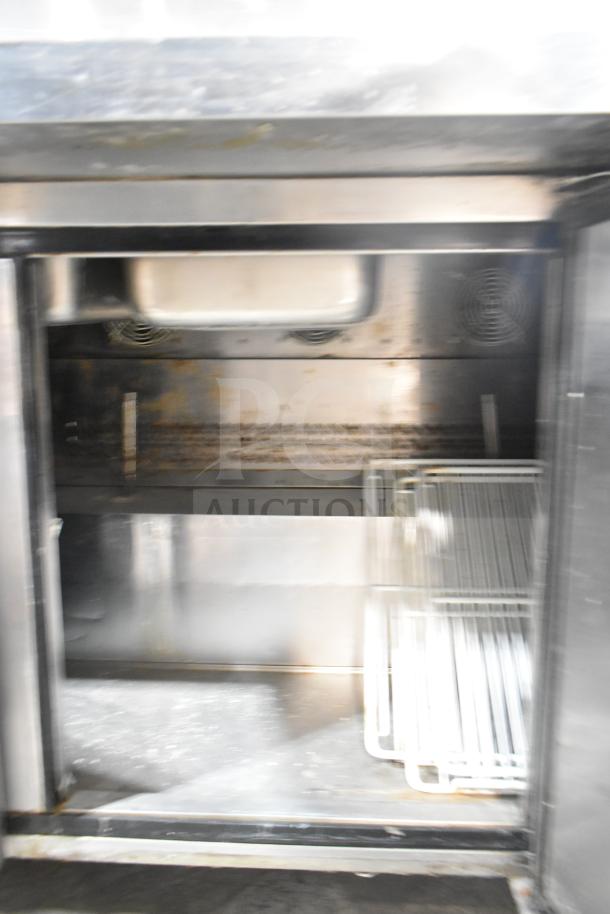 2017 Migali C-SP72-30BT salad prep table interior, stainless steel, commercial casters, 115V, showing storage space.