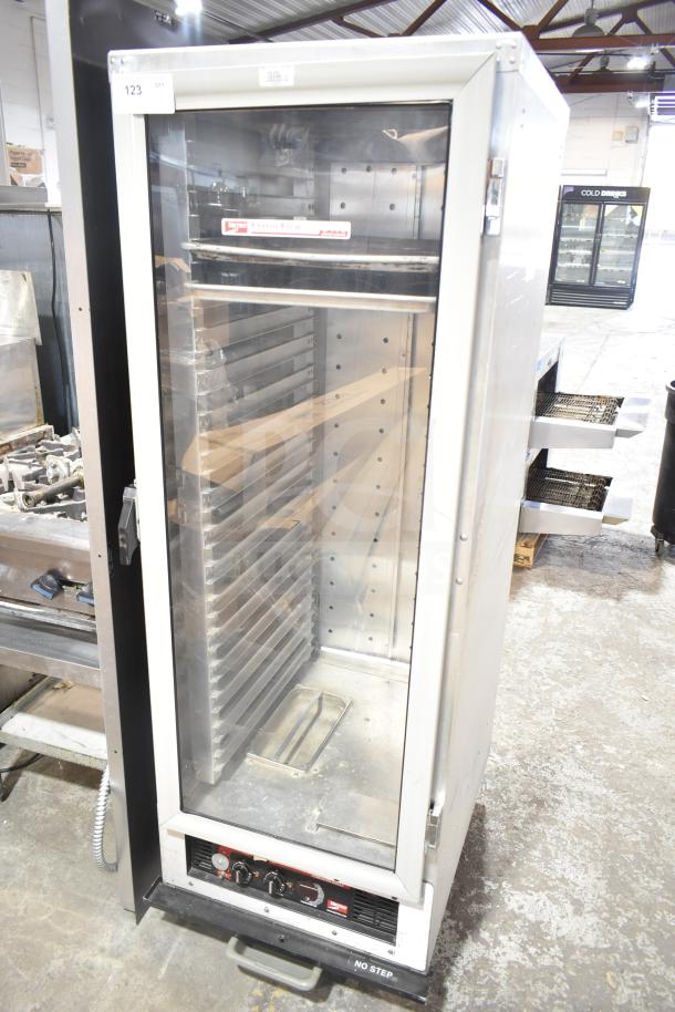 Metro C175-CM2000 heated holding cabinet on casters, 120V, 1 phase, in used condition with clear glass door and metal shelves.
