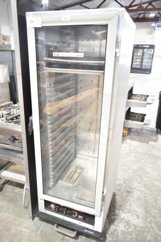 Metro C175-CM2000 heated holding cabinet on casters, 120V, 1 phase, in used condition with clear glass door and metal shelves.