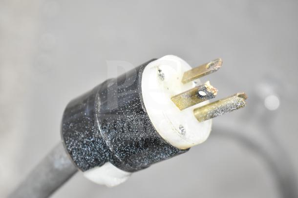 Plug of Metro C175-CM2000 Commercial Heated Holding Cabinet for 120V, 1 Phase. Black and white casing with visible prongs.