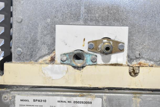 Manitowoc Model SPA310 commercial ice machine component with visible serial number 050263059, showing connection points.