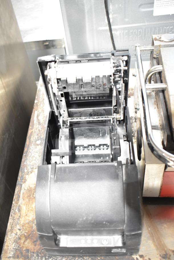 Toast Receipt Printer, black model, open lid showing internal mechanisms, in good condition, on metal surface.