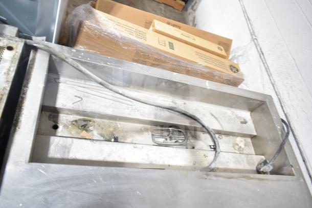 Commercial electric steam table with under shelf, visible wear, power cord attached. Ideal for food service operations.