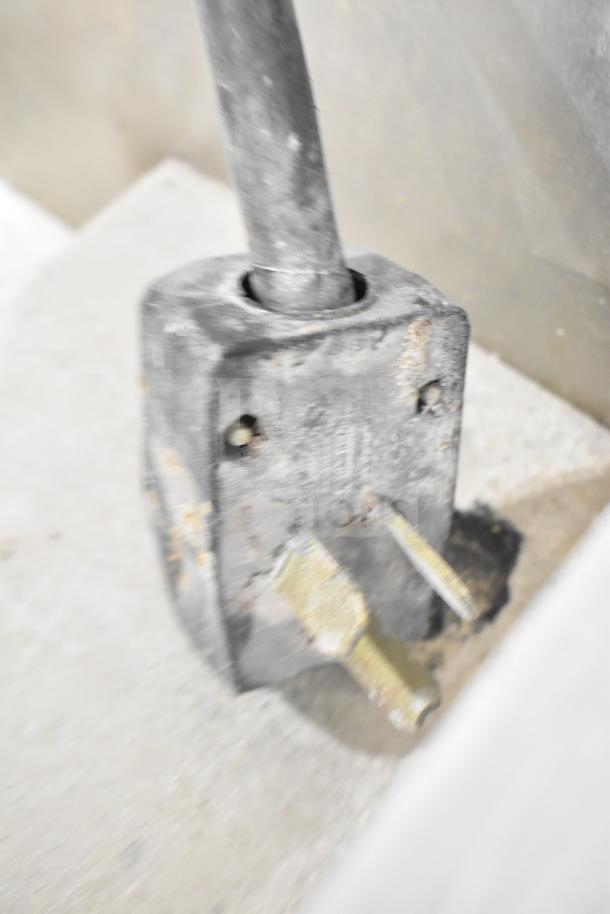 Blurry image of a metal component, possibly related to the Commercial Electric Powered Steam Table. Specific features are unclear.