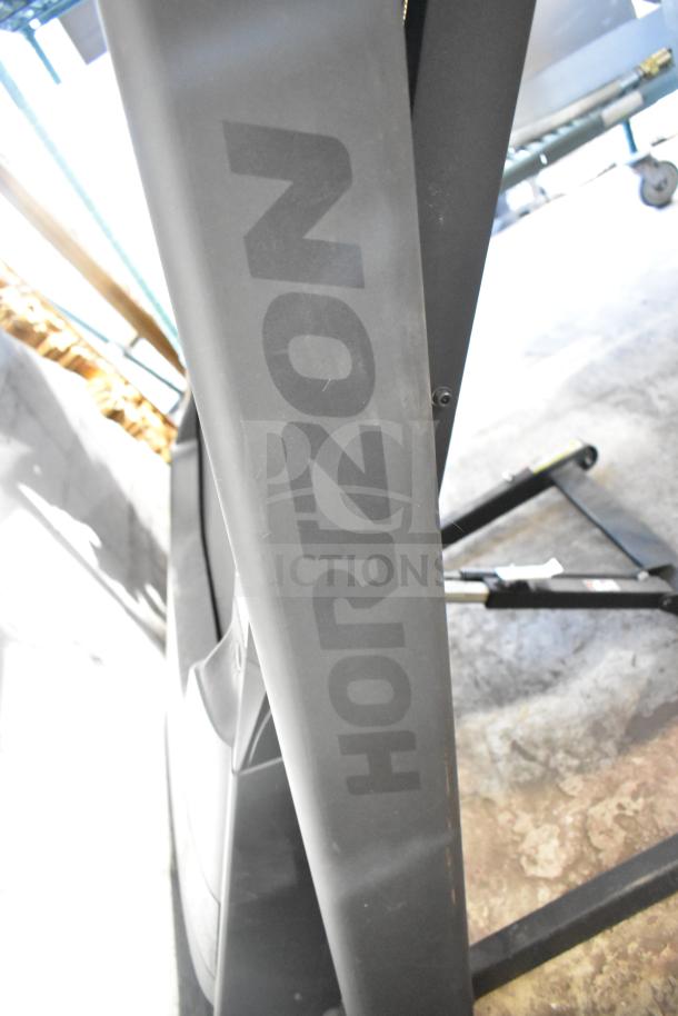 Horizon Folding Treadmill in good condition with visible branding on side panel, demonstrating sturdiness and foldable design.