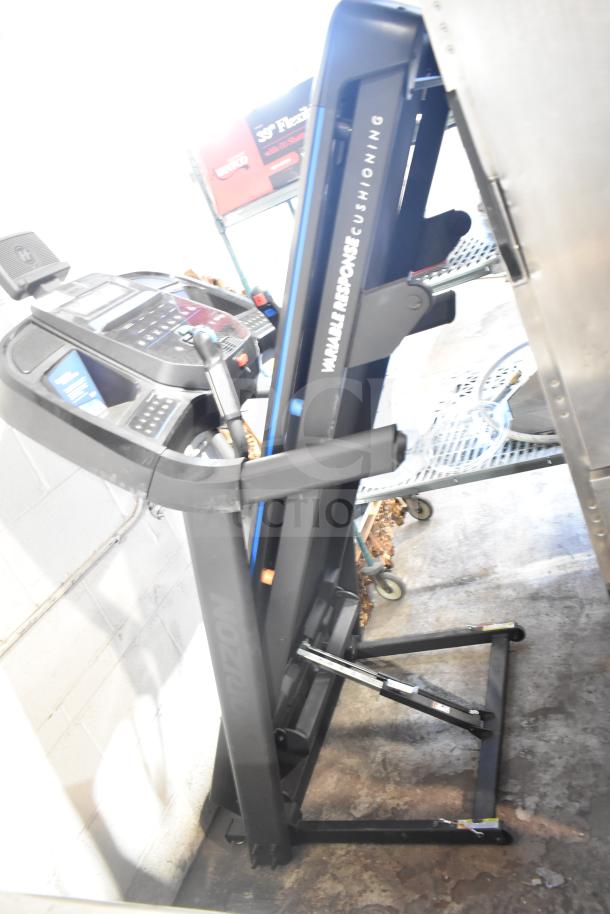 Horizon Folding Treadmill, upright position, black frame, control panel visible, "Variable Response Cushioning" label, used condition.