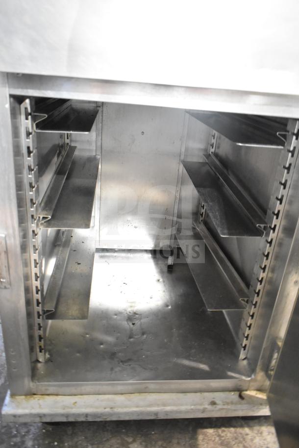 CresCor HU18-671-120 commercial heated holding cabinet with adjustable shelves and commercial casters, interior view.