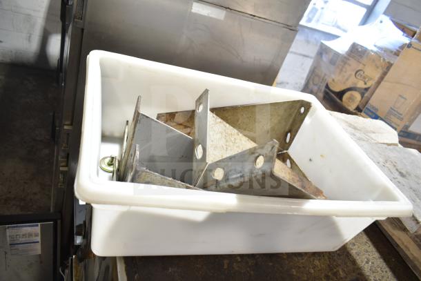 Metal brackets in a white plastic container. Appears to be parts or accessories, possibly for commercial kitchen equipment.