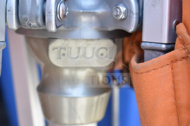 Close-up of a Tuuci patio umbrella mechanism. Orange fabric cover visible, highlighting durability and quality.