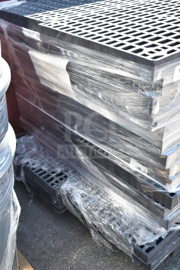 Stack of 32 black poly shelves wrapped in plastic, grid design, auctioned as a bulk item, 32 times your bid.