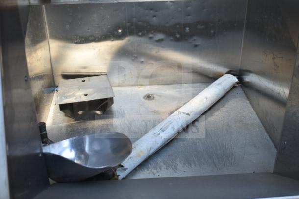 MGR Commercial Ice Bin with metal interior, visible wear, includes scoop and drainage pipe, ideal for high-volume settings.