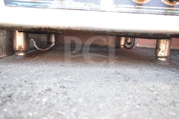 Star Max Commercial 4 Burner Countertop Gas Range, showing undercarriage with metal legs and signs of wear.