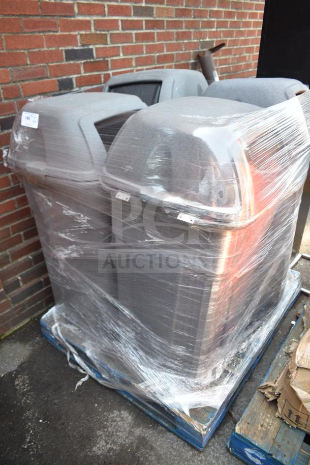 Four gray poly trash cans wrapped on a pallet, indicating new or barely used condition, suitable for commercial use.