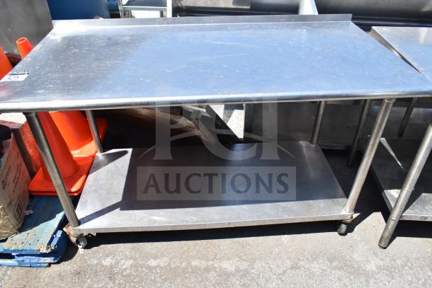 Commercial stainless steel table with under shelf, on casters. Used condition, ideal for kitchen or workspace.