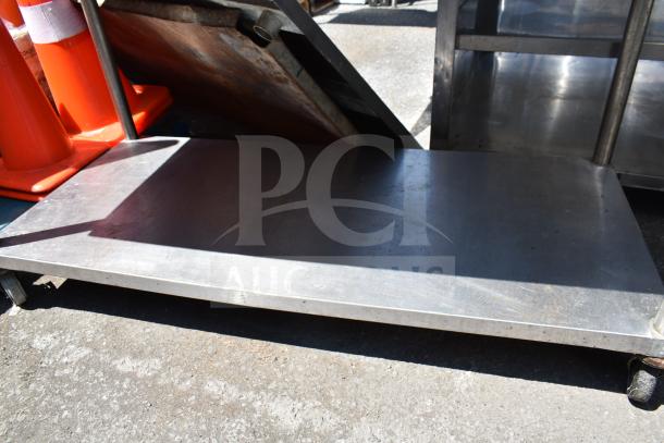 Commercial table with under shelf, on casters, stainless steel. Good condition, ideal for kitchen or industrial use.