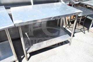 Stainless steel commercial table with under shelf, showing surface wear. Ideal for kitchen use, sturdy design.