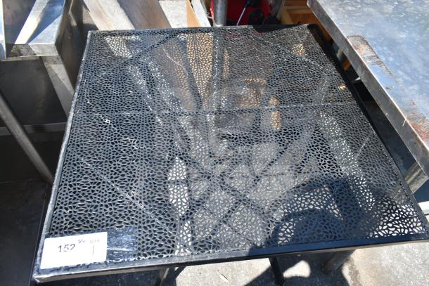 Black mesh patio table with intricate pattern. Metal frame. Sticker reads "152." Suitable for outdoor use.