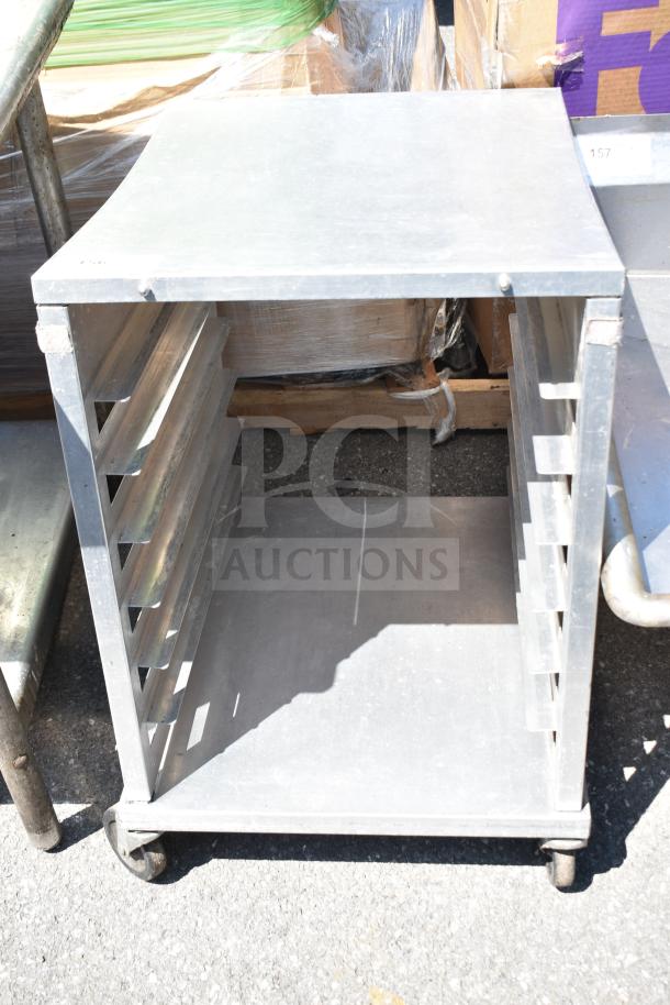 Commercial pan transport rack with sturdy metal frame on durable casters, featuring multiple slots for pan storage.