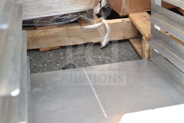 Commercial pan transport rack on casters, metal structure, industrial use, with visible scuff marks, sturdy condition.