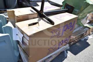 Boxes labeled "FedEx" containing new scratch and dent outdoor table bases on a pallet. Tags and labels present.