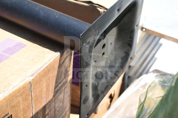 Set of 5 new outdoor table bases with scratch and dent marks, black finish, visible mounting holes on metal base.