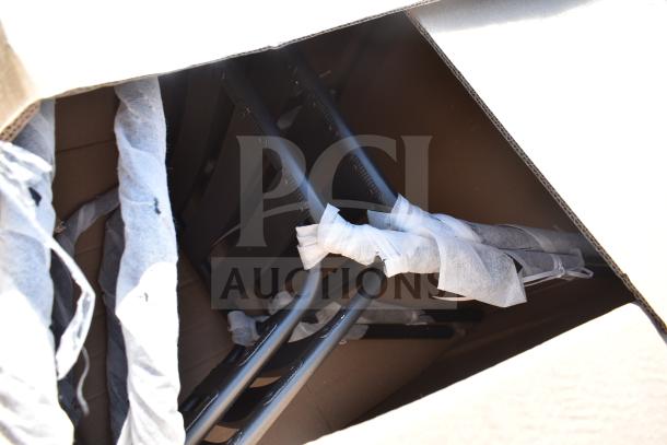 Box containing brand new scratch and dent items, including a black metal café barstool, wrapped for protection.