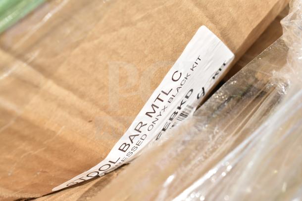 Cardboard box containing a barstool kit labeled "STOOL BAR MTL C, ONYX BLACK KIT." Box shows minor wear.