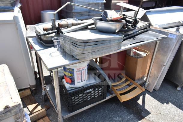 Commercial table with under shelf containing bus bin lids, chair, metal bowl, and a container. Good condition with visible wear.