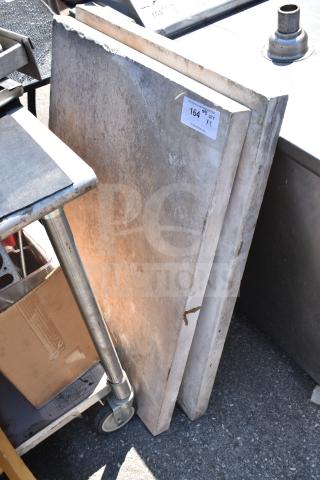 Two stone countertops, rectangular, with visible wear. Auction label "164 QTY X2" attached. Perfect for renovation projects.