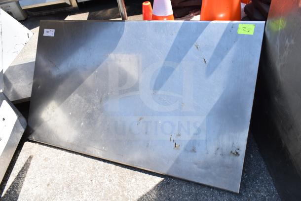 Steel tabletop with visible scratches and wear, rectangular shape. Auction tags indicate numbers 167 and 25.