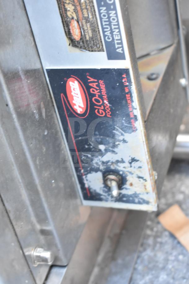 Hatco Glo Ray food warming strip on metal over shelf, shows wear. Label includes logo and model details.