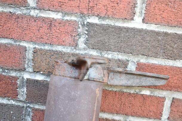 Rustic metal table base against brick wall, showing visible rust and wear. Auction item "3 Table Base. 3 Times Your Bid!"