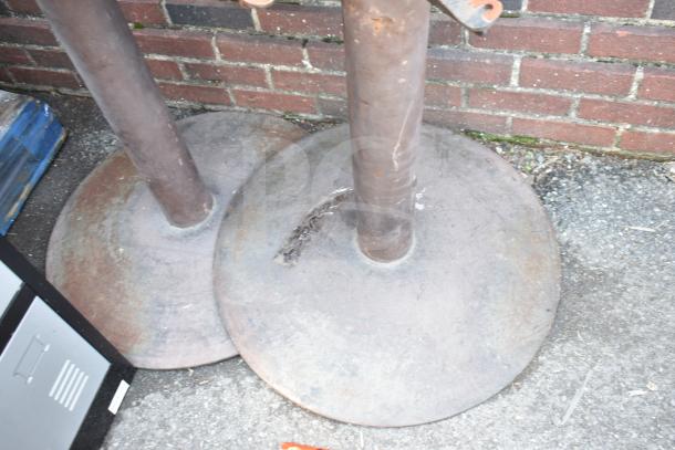 Rustic metal table bases, round and sturdy. Weathered condition, suitable for restoration or industrial decor.